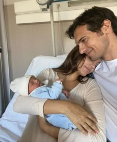 a man and woman holding a baby in a hospital bed