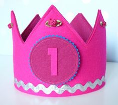 a pink felt crown with the number one on it