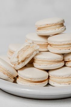 a plate full of white macaroons sitting on top of each other