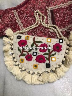 an embroidered purse with tassels and beads