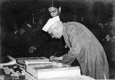 an old black and white photo of a man signing papers