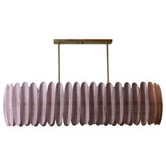 a long light fixture hanging from a wooden bar over a white background with no one in it