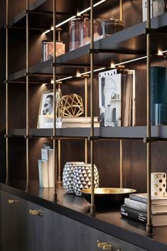 a book shelf filled with books next to a vase and other items on top of it