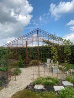 a metal structure sitting in the middle of a garden