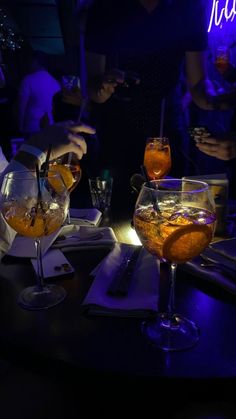 people sitting at a table with drinks in glasses