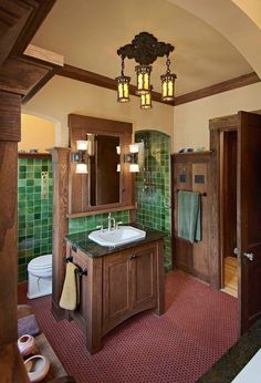 a bathroom with green tile and wooden cabinets