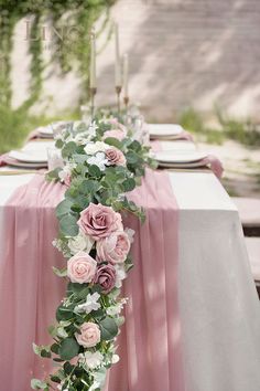 the table is decorated with pink flowers and greenery