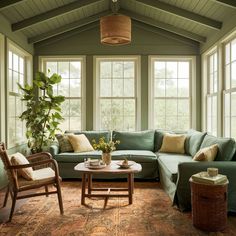 a living room filled with lots of furniture next to large windows on top of a wooden floor