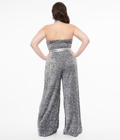 A statuesque 1960's style Smak Parlour plus size jumpsuit crafted in a grey knit that shimmers with silver sequins. The halter keyhole neckline is cinched with a button back while the wide banded waist flatters your figure with a back zipper. The wide legs pants drop to the floor while a sash proves an added accent to your figure!Available in sizes XS-4X while supplies last. Wide Legs Pants, 1960's Style, No Strings Attached, Keyhole Neckline, Plus Size Jumpsuit, 1960s Fashion, Silver Sequin, Wide Legs, Wide Leg Pants