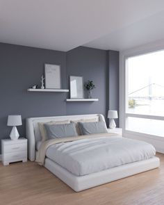 a white bed sitting next to a window in a bedroom on top of a hard wood floor