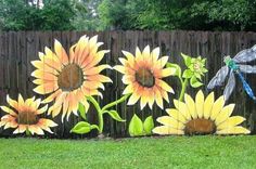 a painting of sunflowers and dragonflies on a fence