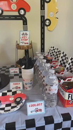 a race car themed birthday party complete with water bottles, plates and napkins on a checkered table cloth