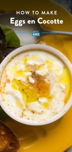 an egg in a bowl on a yellow plate with bread and leaves next to it