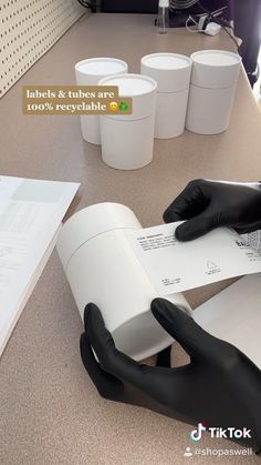 a person in black gloves is holding a roll of paper