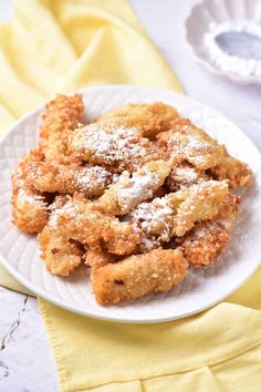 a white plate topped with fried food on top of a table