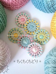 several balls of yarn sitting next to each other on top of a white surface with japanese writing