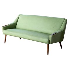 a green couch sitting on top of a wooden frame