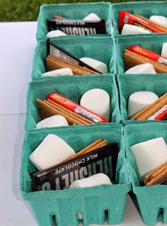 several trays filled with marshmallows, cinnamon sticks and other snacks on a table