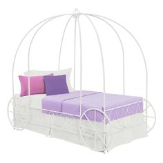 a pink metal bed with purple and white pillows