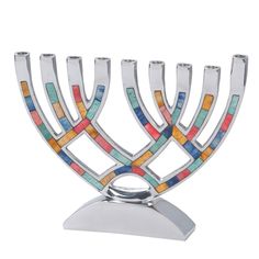 a metal menorah with multicolored tiles on it's sides and a silver base