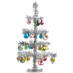 a small silver christmas tree with ornaments on it's branches and tinsels