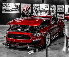 a red car is on display in a showroom