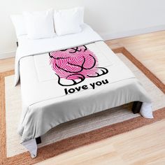 a bed with a pink bear on it and the words love you written in black