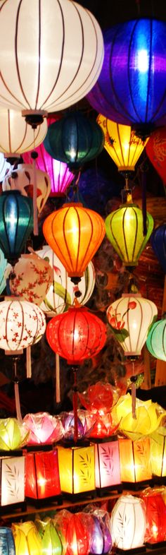 many colorful lanterns are lit up in the dark