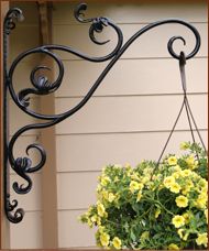 a potted plant hanging from the side of a house with yellow flowers in it