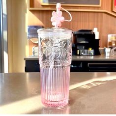 a pink starbucks cup sitting on top of a counter