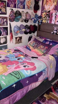 a bed with many pictures on the wall and in front of it is a small child's bed