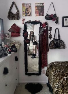 a room with a mirror, leopard print rug and several purses hanging on the wall