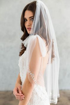 a woman in a wedding dress with a veil on her head