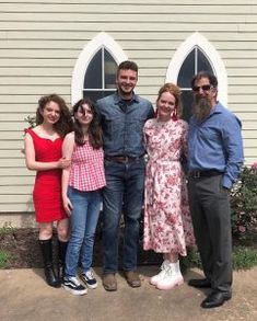 a group of people standing in front of a house