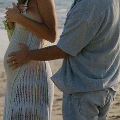 a man standing next to a woman on top of a beach