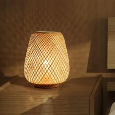 a wooden table with a lamp on top of it next to a night stand and nightstand