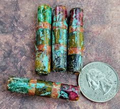 three different colored rocks next to a penny