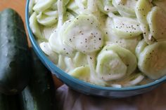 a blue bowl filled with pasta and cucumbers