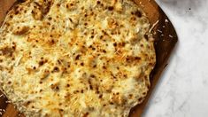 a pizza sitting on top of a wooden cutting board