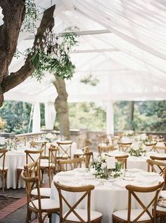 tables and chairs set up under a white tent