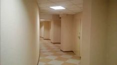 an empty hallway with white walls and checkered floor