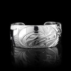 This gorgeous Wolf bracelet has been hand carved by Kwakwaka'wakw artist Cristiano Bruno using sterling silver. This stunning wide cuff bracelet belongs to his "Every Child Matters" collection and shows the Baby Wolf being watched over by its mother who is depicted in silver on the side of the piece. The Wolf bracelet has a width of 1", length is 6.25" and the gap is 0.9". WOLVES SYMBOLIZE: LOYALTY, TEACHER, COOPERATION Wolf symbolizes perseverance, intuition, loyalty, and success. The teacher of new ideas and wisdom, Wolf shows intense loyalty balanced with independence. Wolves are proficient hunters and have always been greatly respected for their cleverness. Because they might bestow this hunting prowess on people, wolves have often been called upon as spirit helpers. Like Orcas, Wolves Baby With Mother, Wolf Bracelet, Every Child Matters, Baby Wolf, Wide Cuff Bracelets, Mens Jewelry Necklace, Watch Chain, Wide Cuff, Mother And Baby