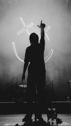 a man standing on top of a stage with his arms in the air