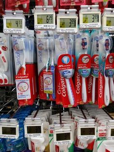 several toothbrushes are on display for sale in a store with the time displayed