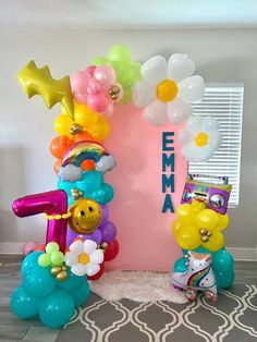 the balloon arch is decorated with flowers and balloons for an entrance to a birthday party