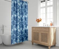 a blue and white shower curtain in a bathroom with a sink, toilet and bathtub