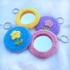 four crocheted mirrors with flowers on them