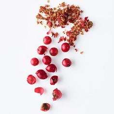 cranberries are scattered on a white surface with pieces cut out to look like they have been chopped up