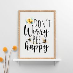 a poster with the words don't worry, bee happy on it next to some flowers