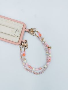 Marigold is a charming and playful accessory to keep your phone secure in style. This handmade wristlet features soft pastel beads, accented with delicate floral details and gold hardware for a touch of elegance. Lightweight and easy to carry, the Marigold wristlet is perfect for adding a pop of color to your day while keeping your phone close at hand. Whether you're out running errands or dressing up for an occasion, this wristlet combines function and fashion effortlessly. Chain: The beaded wr Chain Braid, Handmade Wristlet, Pastel Beads, Phone Wristlet, Wrist Wallet, Soft Autumn, Phone Wallet, Boho Vibe, Color Themes